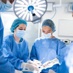 Four people in scrubs in surgery theatre
