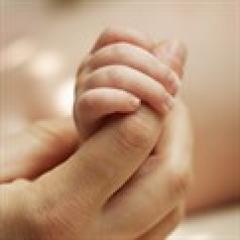 Baby holding mum's finger